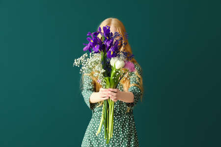 Woman holding beautiful bouquet on color backgroundの写真素材