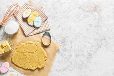 Fresh dough and tasty Easter cookies on light backgroundの写真素材