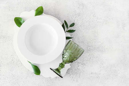Stylish table setting and green leaves on light backgroundの写真素材