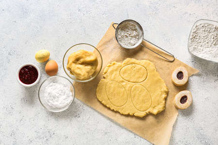 Fresh dough and ingredients for preparing Easter cookies on light background