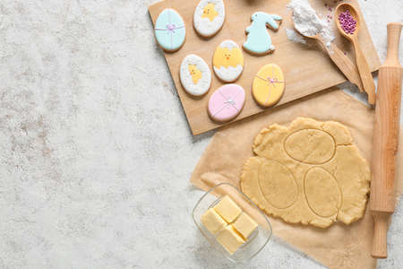 Fresh dough and tasty Easter cookies on light backgroundの写真素材