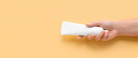 Female hand with tooth paste on beige background with space for text