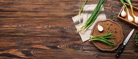 Composition with green onion on wooden background with space for text, top viewの写真素材