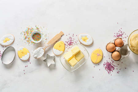 Tasty Easter cookies and ingredients on light backgroundの写真素材