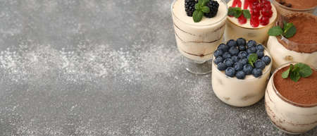 Glasses with tasty tiramisu on grunge background with space for textの写真素材