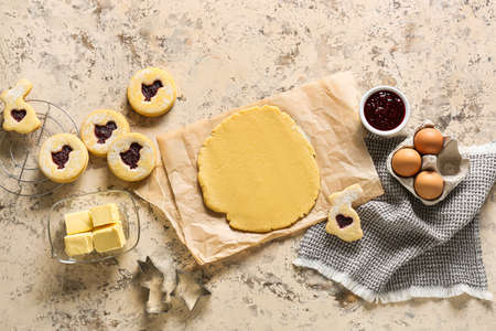 Fresh dough and ingredients for preparing Easter cookies on beige backgroundの写真素材