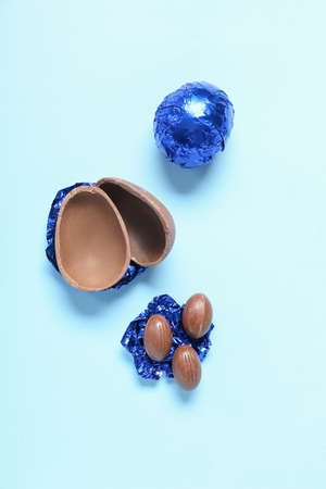 Delicious chocolate Easter eggs on color background