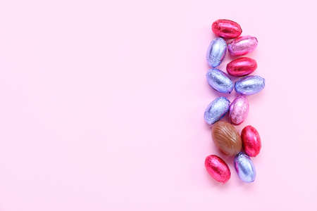 Tasty chocolate eggs on pink background