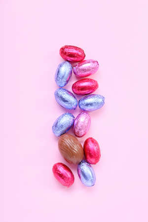 Tasty chocolate eggs on pink background