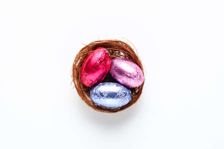 Nest with chocolate Easter eggs isolated on white backgroundの写真素材