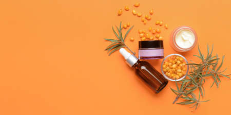 Healthy sea buckthorn cosmetics on orange background with space for textの写真素材