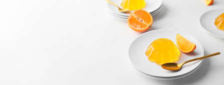 Plate with tasty orange jelly on white background with space for text