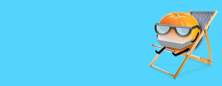 Funny orange relaxing on deck chair against blue background with space for textの写真素材