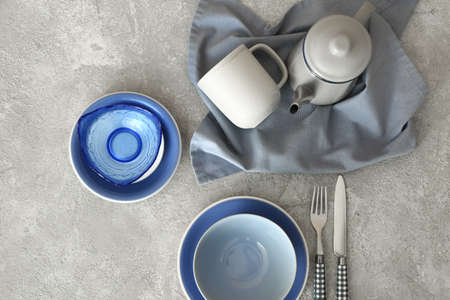 Elegant table setting with plates, cup and teapot on gray backgroundの写真素材
