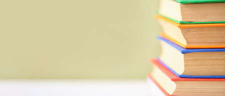 Stack of books on color background with space for text, closeupの写真素材