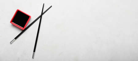 Bowl of soy sauce and chopsticks on light background with space for text, top viewの写真素材