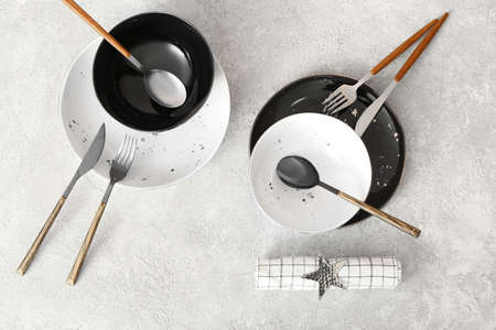 Elegant black and white plates and cutlery on gray background