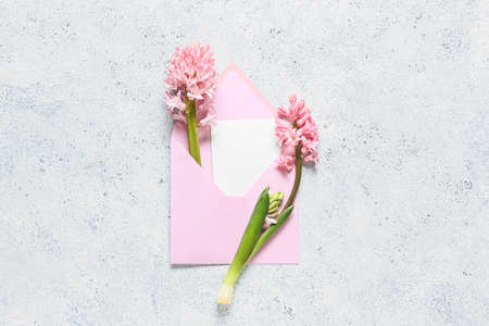 Envelope with card and hyacinth flowers on light backgroundの写真素材