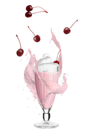 Glass of tasty cherry milkshake with splashes on white backgroundの写真素材