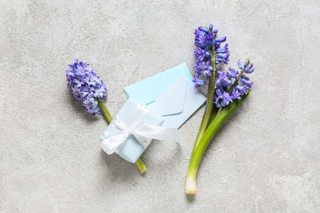 Beautiful hyacinth flowers, gift box and envelopes on light backgroundの写真素材