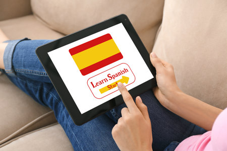 Woman with tablet computer studying Spanish at homeの写真素材