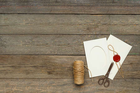 Envelope with card, scissors and rope on dark wooden backgroundの写真素材