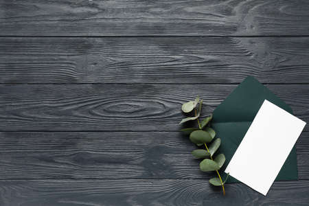 Envelope with blank card and eucalyptus branch on dark wooden backgroundの写真素材