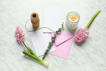 Envelope with blank cards, candle, flowers, eucalyptus and rope on white backgroundの写真素材