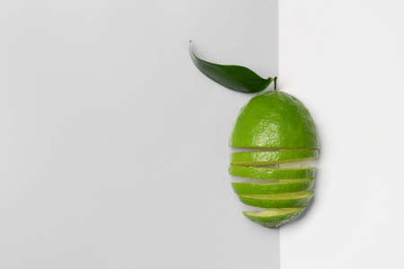 Composition with cut ripe lime on light background