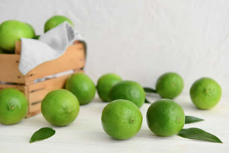 Fresh ripe limes on light wooden tableの写真素材