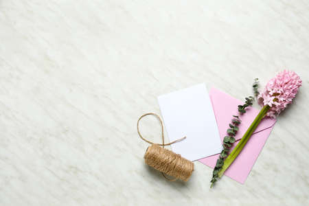 Envelope with blank card, eucalyptus, flowers and rope on white background