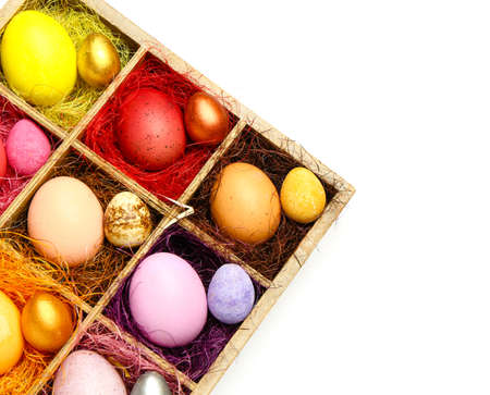 Box with painted Easter eggs on white background