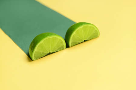 Slices of ripe lime on color backgroundの写真素材