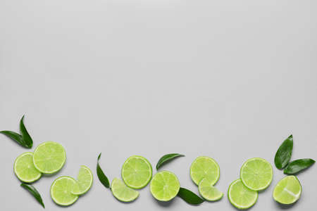 Composition with cut limes and leaves on light backgroundの写真素材