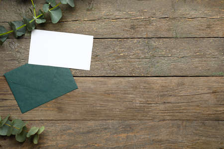 Envelope with blank card and eucalyptus branches on dark wooden backgroundの写真素材