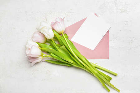 Envelope with blank card and tulips on white backgroundの写真素材