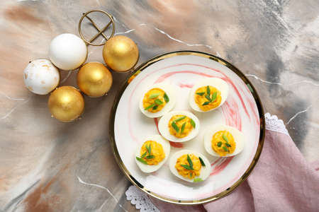 Holder and plate with stuffed eggs on grunge background. easter celebration