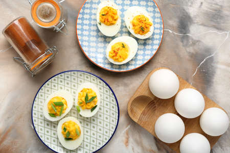 Plates with stuffed eggs and spices on grunge background. easter celebration