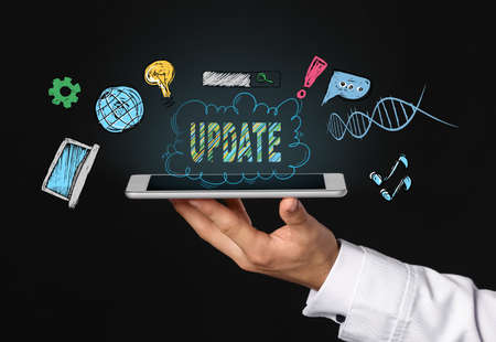 Hand of businesswoman with tablet computer on dark background. concept of updateの写真素材