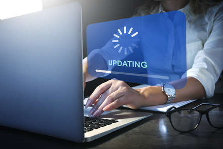 Young woman updating laptop softwareの写真素材