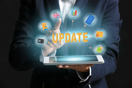 Businesswoman with tablet computer on dark background. concept of updateの写真素材