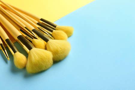 Set of makeup brushes on blue and yellow background, closeupの写真素材