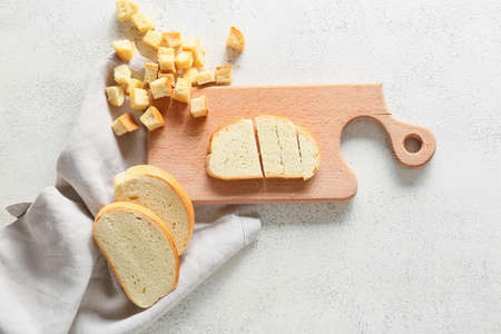 Board with tasty croutons and bread slices on white backgroundの写真素材