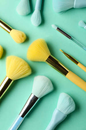 Set of makeup brushes on blue background, top view