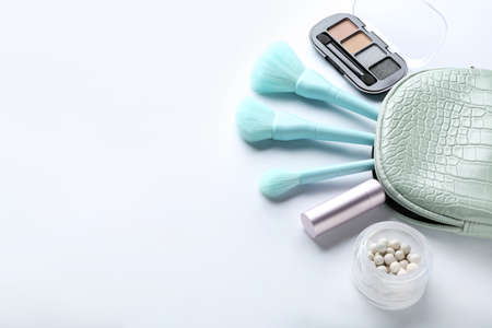 Bag with cosmetics and makeup brushes isolated on white