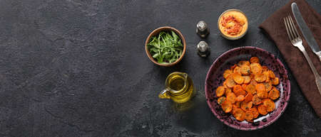 Plate with tasty baked carrots on dark background with space for textの写真素材