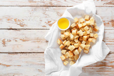 Napkin with tasty croutons and oil on light wooden backgroundの写真素材