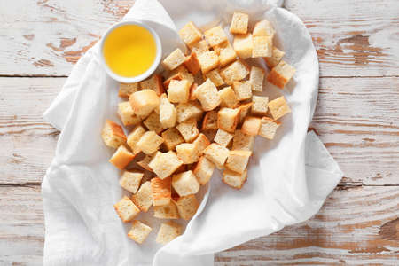 Napkin with tasty croutons and oil on light wooden backgroundの写真素材