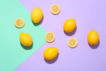 Ripe lemons and slices on color background, top viewの写真素材