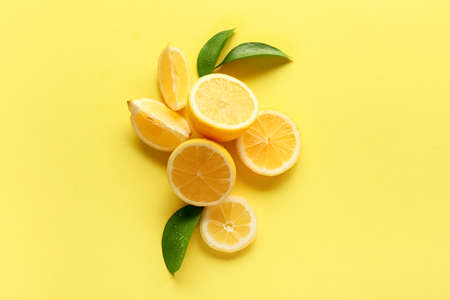 Ripe cut lemons on yellow background, top view